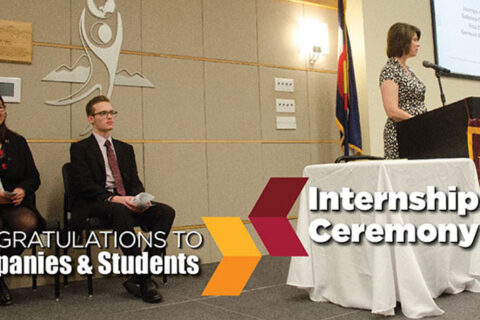 a student delivering speech with teachers sitting beside her