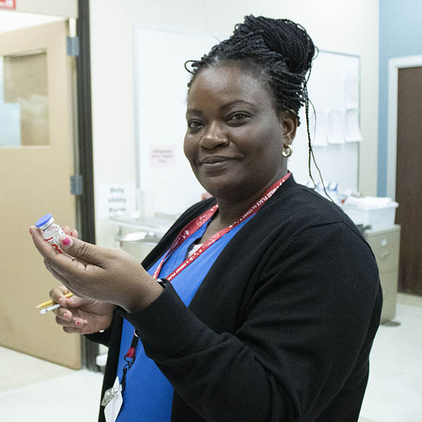 female nurse holding vial