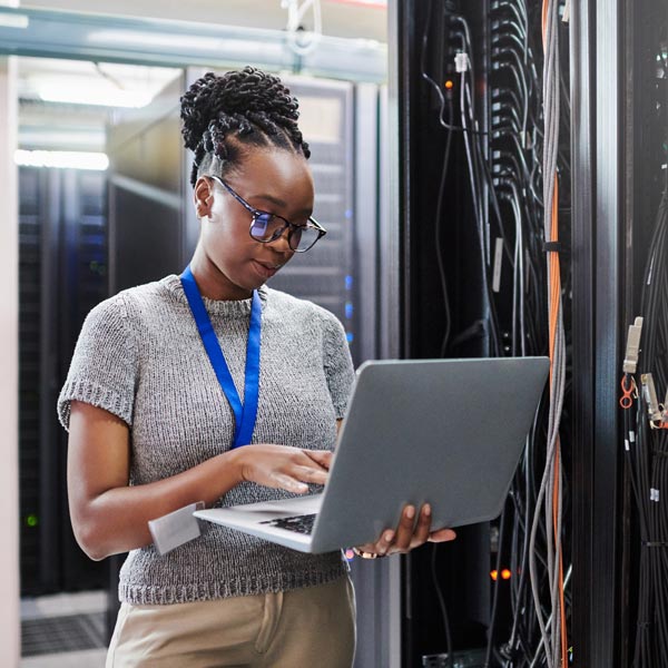 woman holding laptop in server room