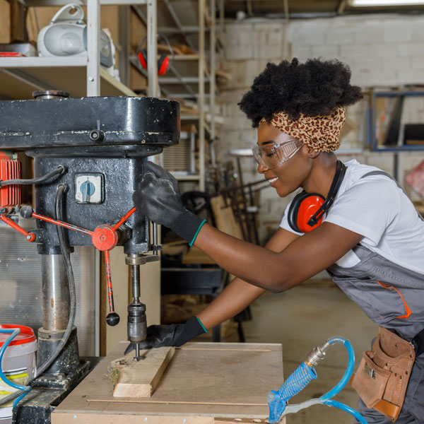 person working with drill press