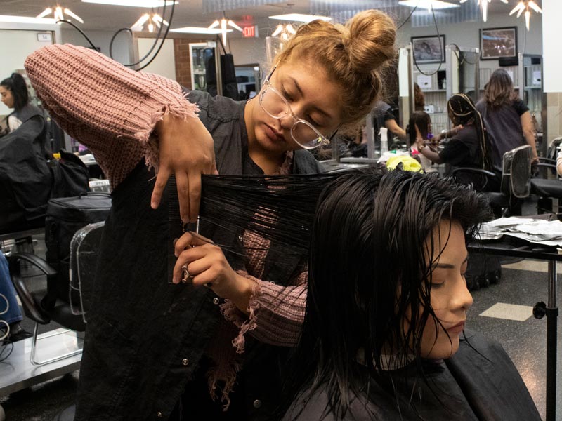 person cutting another person's hair