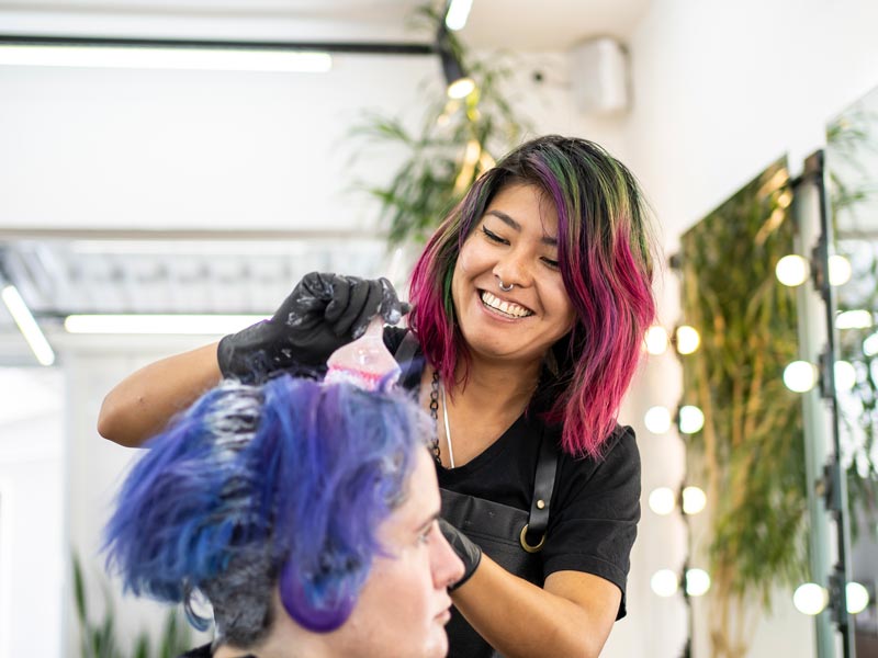 cosmetologist dying woman's hair blue