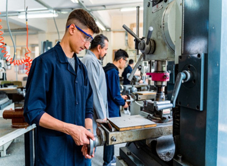 Student learning CNC machining manufacturing process in Aurora, CO